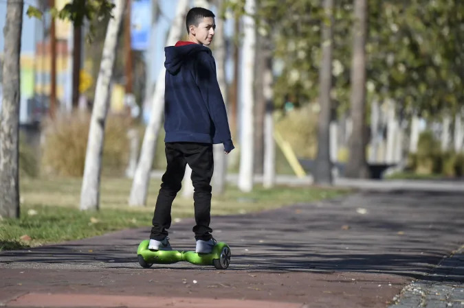 A boy rides a hoverboard on the day after Christmas, in San Pedro, California December 26, 2015. Reports of some hoverboards, also known as self-balancing, two-wheeled scooters catching fire have led to an investigation by the Consumer Product Safety Commission.  AFP PHOTO / ROBYN BECK / AFP / ROBYN BECK        (Photo credit should read ROBYN BECK/AFP via Getty Images)