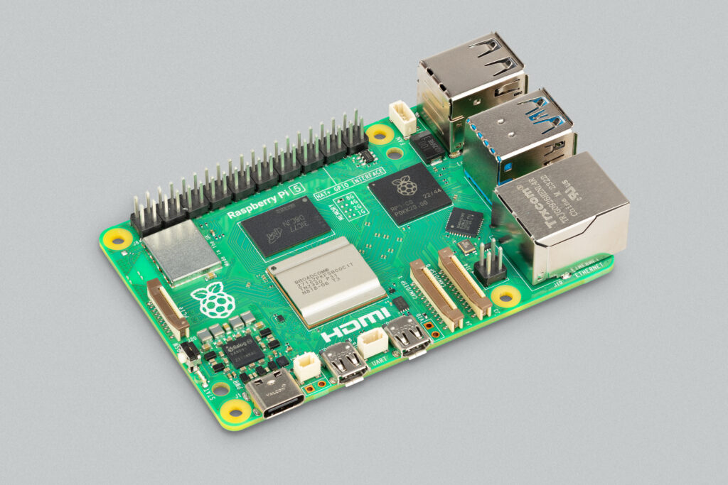 A Raspberry Pi 5, photographed corner-on, against a plain grey background.