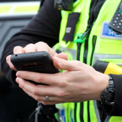 police officer looking up data on a smartphone