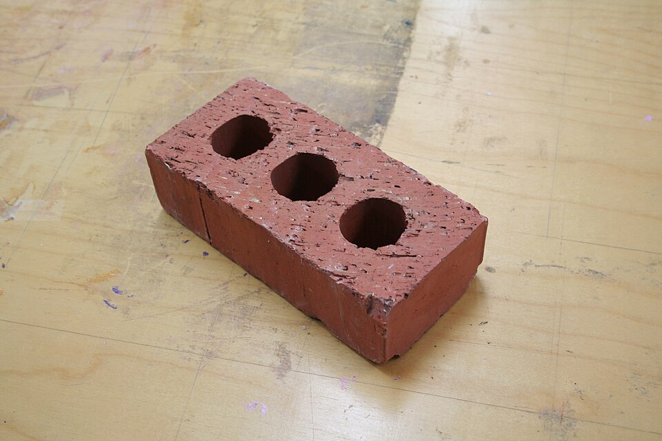 A red brick on a wooden floor